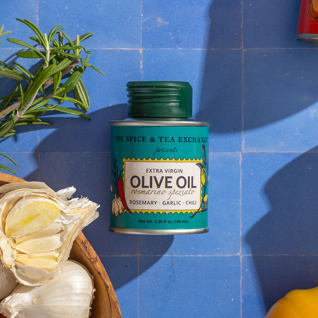 Can of Rosemary Garlic Chili Extra Virgin Olive Oil - Mini with rosemary, garlic, and chili on a blue tiled background